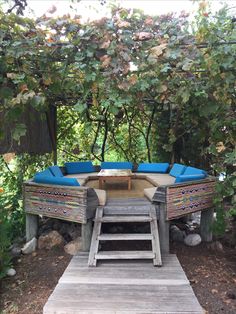 an outdoor seating area with blue cushions and wooden steps