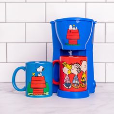 two coffee mugs sitting next to each other on top of a white tile counter