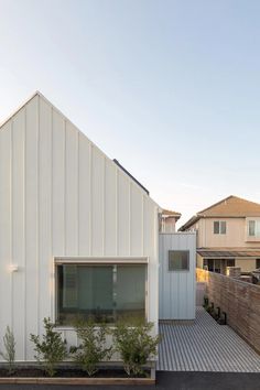 the house is white and has a wooden deck