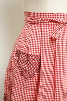 a woman's red and white checkered skirt with a heart patch on it