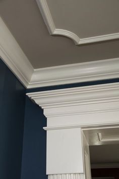 the corner of a room with blue walls and white molding on the trimming