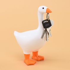 a white duck with keys in it's beak and keychain attached to its neck