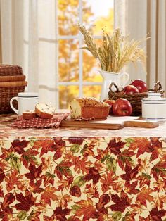 a table topped with fruit and bread next to a window