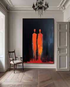 an abstract painting hangs on the wall next to a chair in a room with white walls