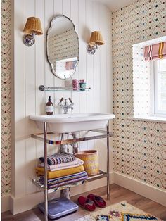 a white sink sitting under a mirror in a bathroom