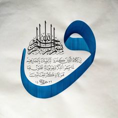 an arabic calligraphy on white paper with blue ribbon in the shape of a heart