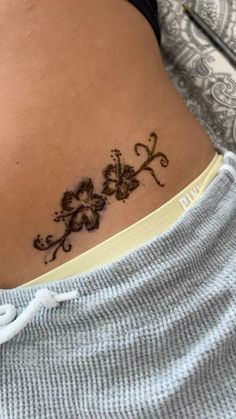 a woman with a tattoo on her stomach that has flowers and vines drawn on it