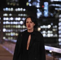 a woman standing in front of a city at night