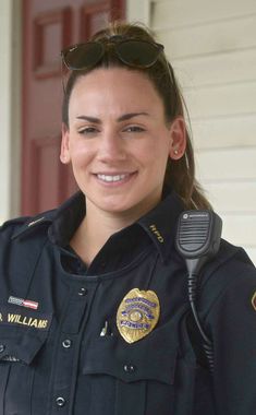 a woman police officer is smiling for the camera