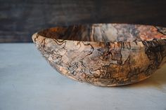 a wooden bowl sitting on top of a table