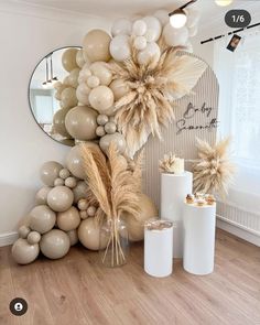 balloons and decorations are arranged on the wall in front of a mirror, vases with flowers