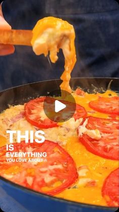 a person holding a piece of pizza with cheese and tomatoes on it in a skillet