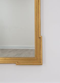 a gold framed mirror hanging on the wall