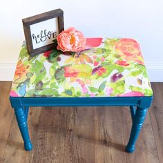 a small table with a flower on top and a sign that says life love written on it