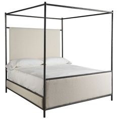 an iron bed frame with white linens and pillows on the bottom, against a white background