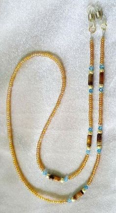 This is such a pretty chain to wear with those reading glasses, readers or sunglasses that you don't want to lose or be without. It is approx 29" long and strung on 49 strands of wire coated in nylon. The strongest most flexible material available to string on. It is done with genuine Tiger Eye tube beads with Aquamarine FINE Austrian crystals and topaz ab Chech glass seed beads. The ends are tubes that have movable  springs to tighten up on any size arms. Payment Methods / Shipping Terms: shipp Adjustable Gold Crystal Glass Necklace, Beaded Eyeglass Chain, Eyeglass Jewelry, Eyeglass Chain Holders, Eyeglass Necklace, Horseshoe Pendant, Horseshoe Necklace, Diamond Cross Pendants, Eyeglass Chain