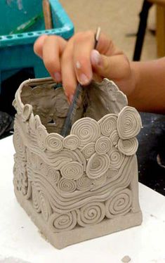 a person is making a vase out of clay