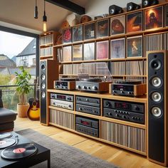 a living room filled with lots of furniture and sound equipment on display in front of a large window