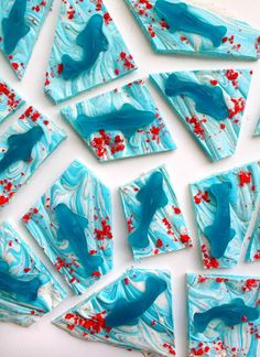 blue and white marbled paper with red sprinkles on it, cut into squares