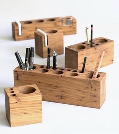 several wooden boxes with pens and pencils in them