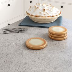 a pie sitting on top of a counter next to four plates