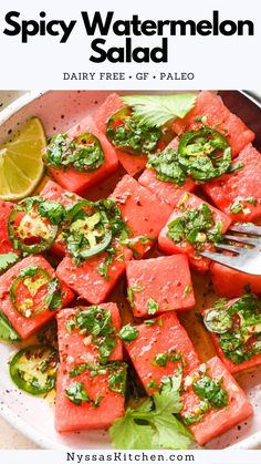 watermelon salad in a white bowl with limes on the side