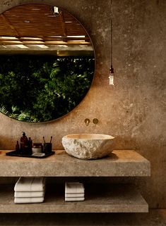 a bathroom with a large round mirror above the sink