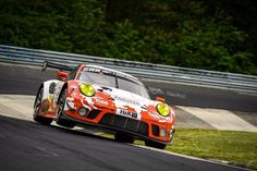 a race car driving on a track with trees in the background