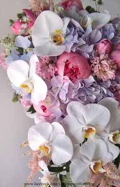 a vase filled with lots of white and pink flowers