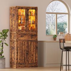 a wooden cabinet sitting in the middle of a kitchen next to a potted plant