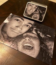 a puzzle with the faces of two people on it next to a piece of jigsaw