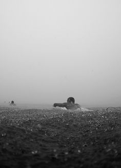 a man laying on top of a field next to a kite flying in the sky