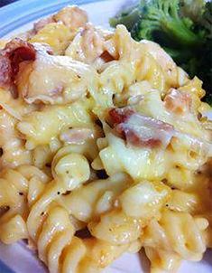 a plate with pasta, broccoli and bacon on it next to a fork