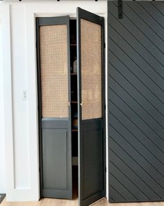 an open closet door in the corner of a room with wooden floors and white walls