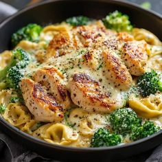 a skillet filled with chicken, broccoli and noodles