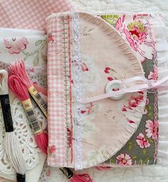 some pink and white items are laying out on the bed together with crochet hooks