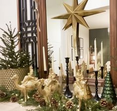 a christmas mantel with candles, ornaments and a star on it in front of a mirror