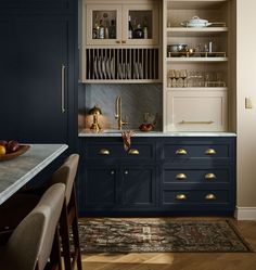 a kitchen with dark blue cabinets and gold pulls on the cupboards is pictured in this image