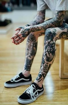 a man with tattoos sitting on a bench