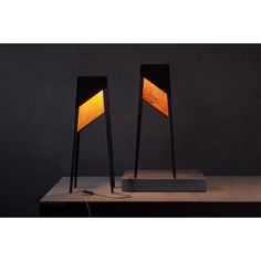 two lamps sitting on top of a table next to each other with one light turned on