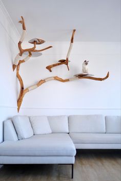 a white couch sitting next to a wooden tree branch