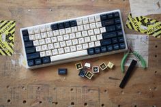 a keyboard and some other items on a wooden table with yellow stickers around it