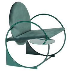 a green chair sitting on top of a metal stand next to a white table with a circular