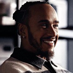 a man with dreadlocks smiling at the camera