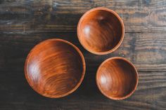 three wooden bowls sitting on top of a wooden table