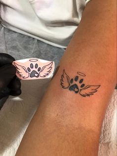 a person with a dog paw tattoo on their arm