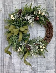 a christmas wreath with pine cones and greenery