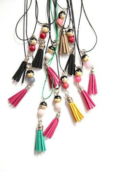 a bunch of tassels that are hanging from a necklace on a white surface