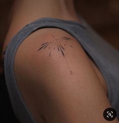 a woman's arm with a tattoo on it that has a dandelion