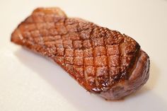 a piece of meat sitting on top of a white plate